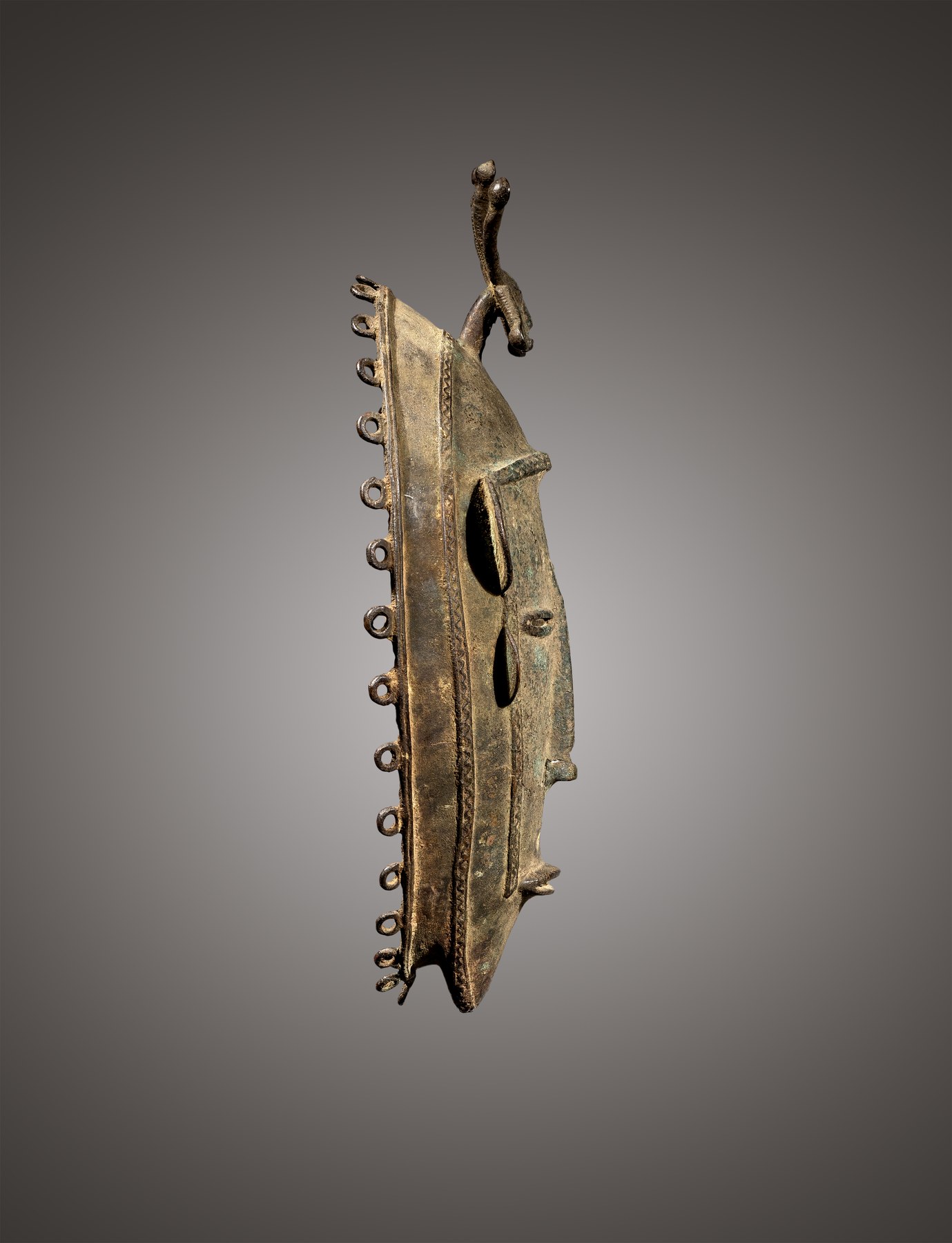 Diula face mask, Mankono area, Ivory Coast, 19th century, non-ferrous metal alloy, profile view