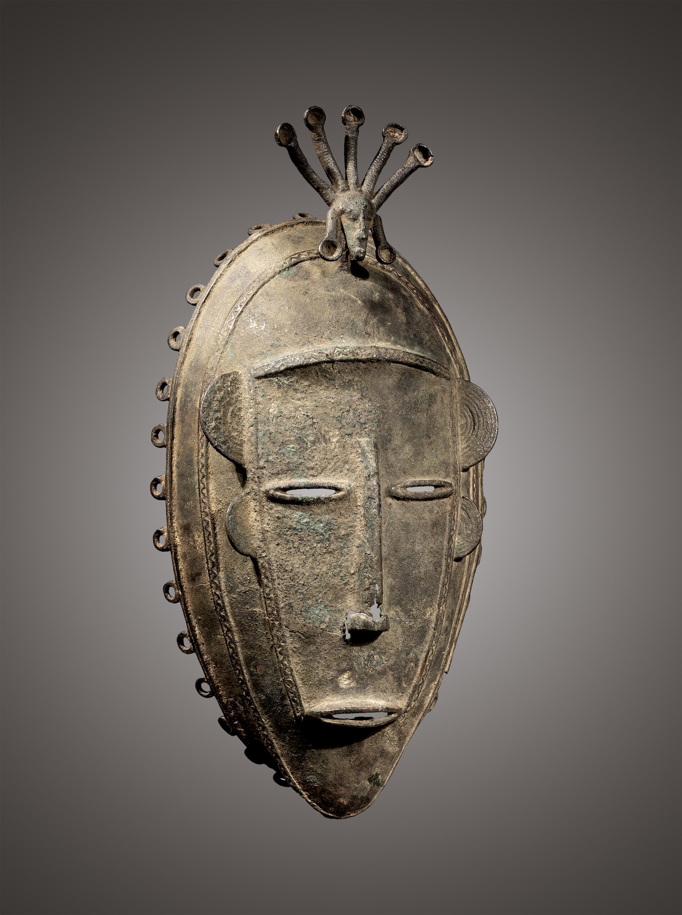Diula face mask, Mankono area, Ivory Coast, 19th century, non-ferrous metal alloy, three-quarter view